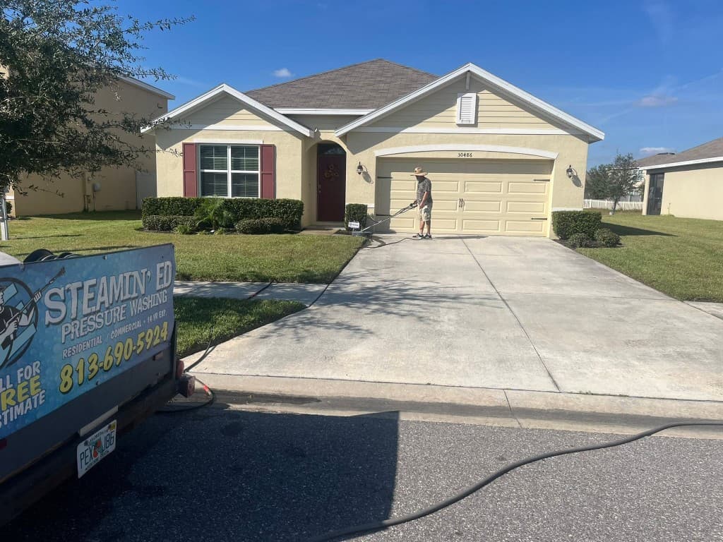 Technician using a surface cleaner on a residential concrete driveway