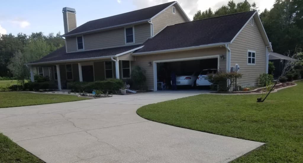 Two-story tan suburban home with concrete driveway in Land O' Lakes