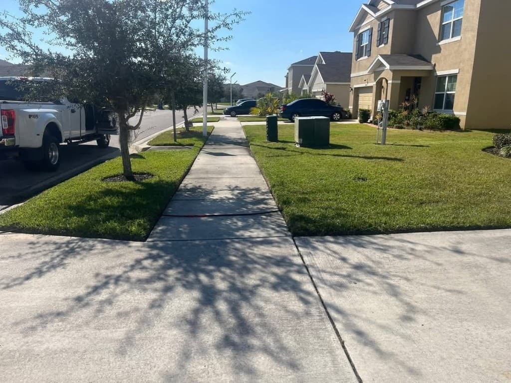 Clean concrete sidewalk and driveway after pressure washing in a suburban neighborhood