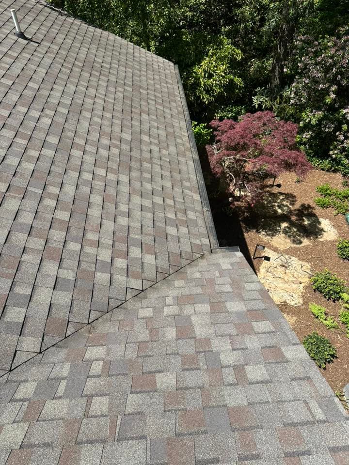 Soft washing a mossy tile roof to remove algae and organic growth